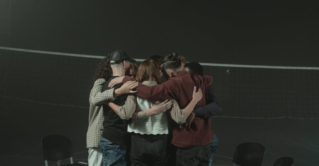 A small group of diverse adults embracing in a supportive circle indoors, symbolizing unity and support.